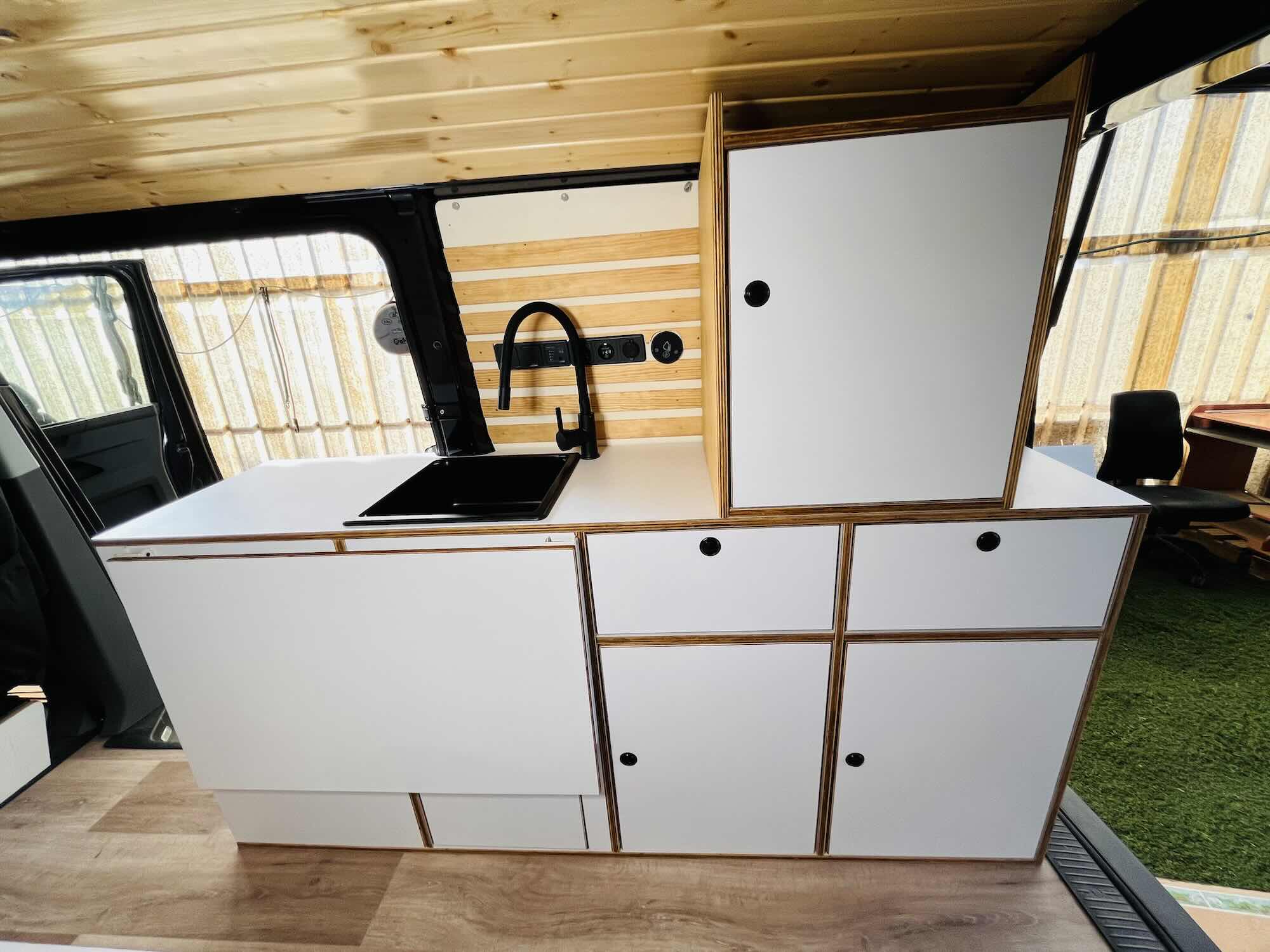 Volkswagen T6 Andrómeda camper conversion interior with custom furniture and wood finish