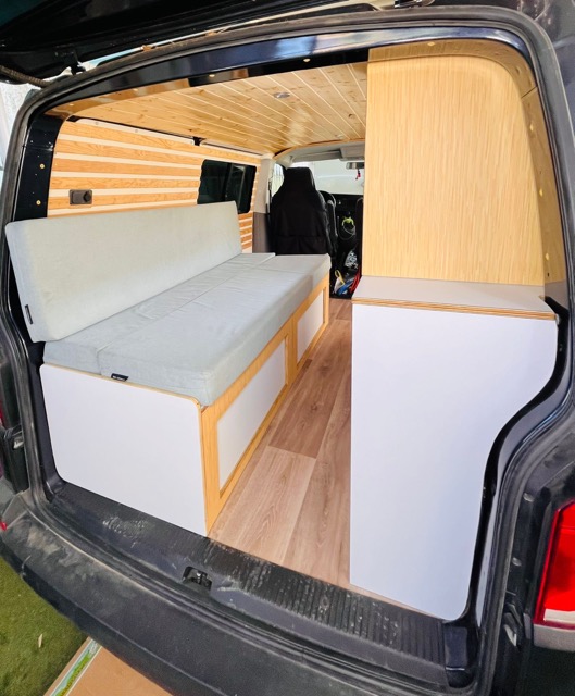Volkswagen T6 Andrómeda camper conversion interior with custom furniture and wood finish